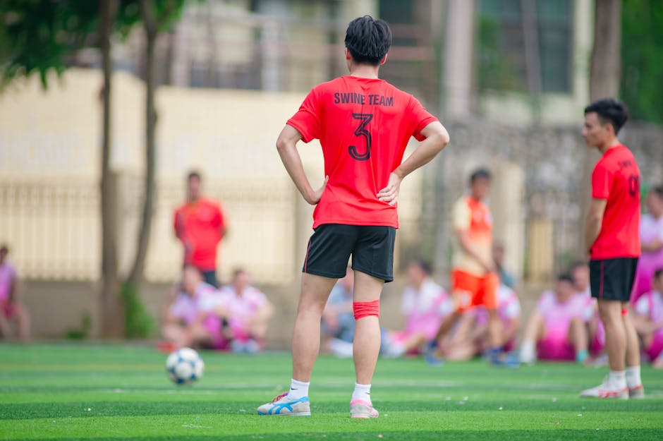 Amateur soccer players in vibrant jerseys on a field in Hanoi, Vietnam.
