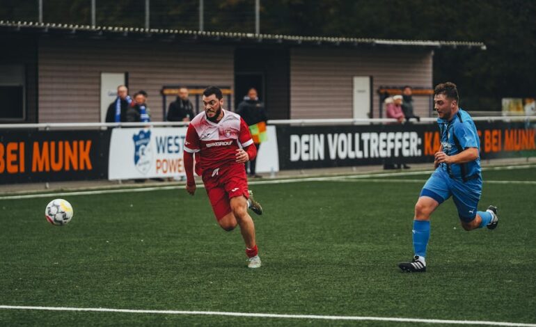 Two male soccer players compete fiercely on a grass field. Outdoor sports scene.