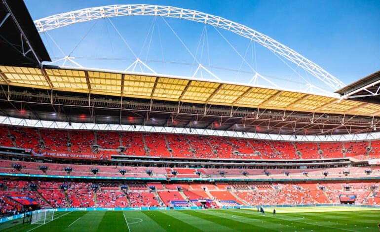 Stunning view of Wembley Stadium, England's iconic football venue, under clear blue skies.