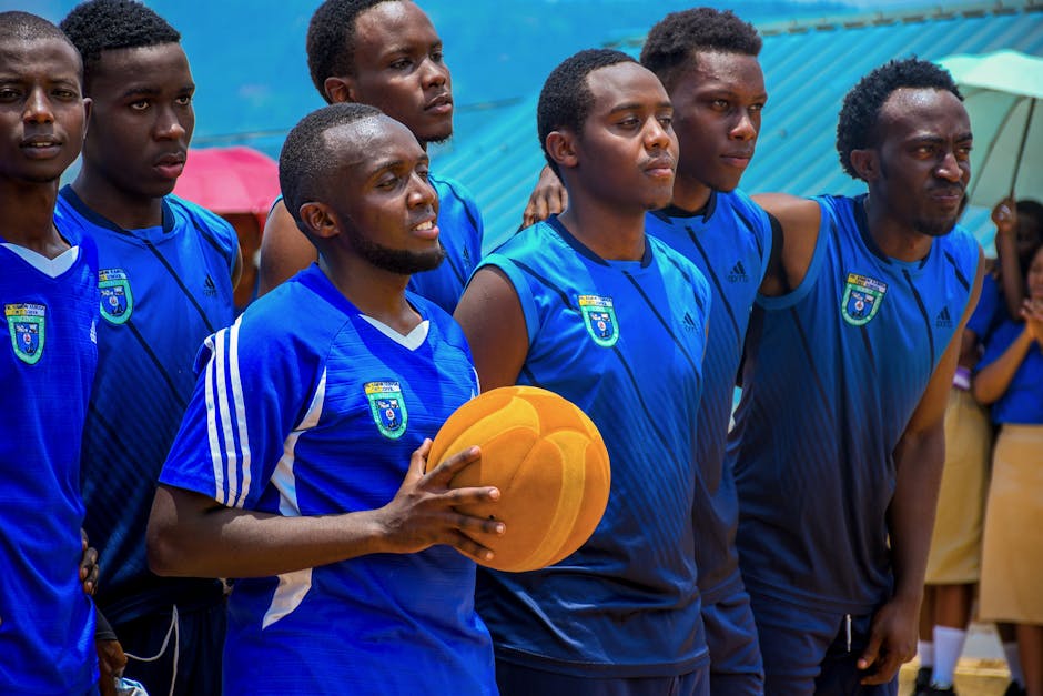 Basketball team in blue uniforms holding a ball, preparing for a game, showing team spirit.