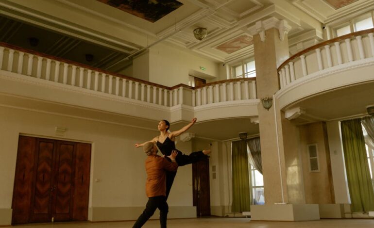 A couple gracefully performs a contemporary dance in a beautiful, spacious interior with classical architecture.