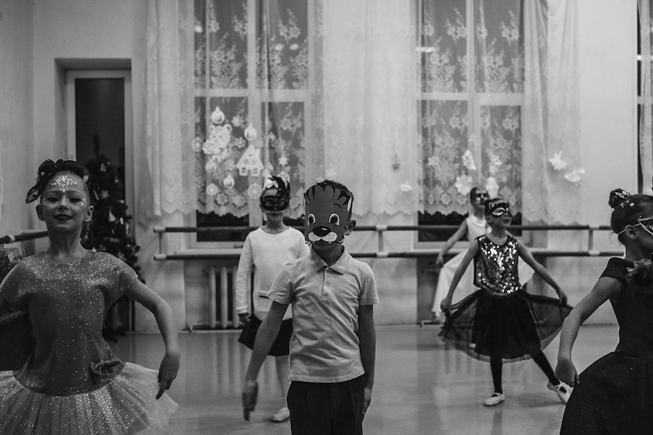Black and white photo of children rehearsing masked dance indoors.