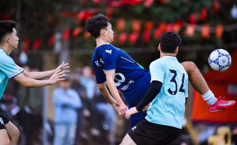 Energetic football players in action during a match in Hanoi, Vietnam.