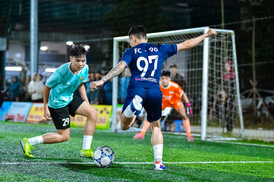 Dynamic football action capture during an evening match in Hà Nội, Vietnam.