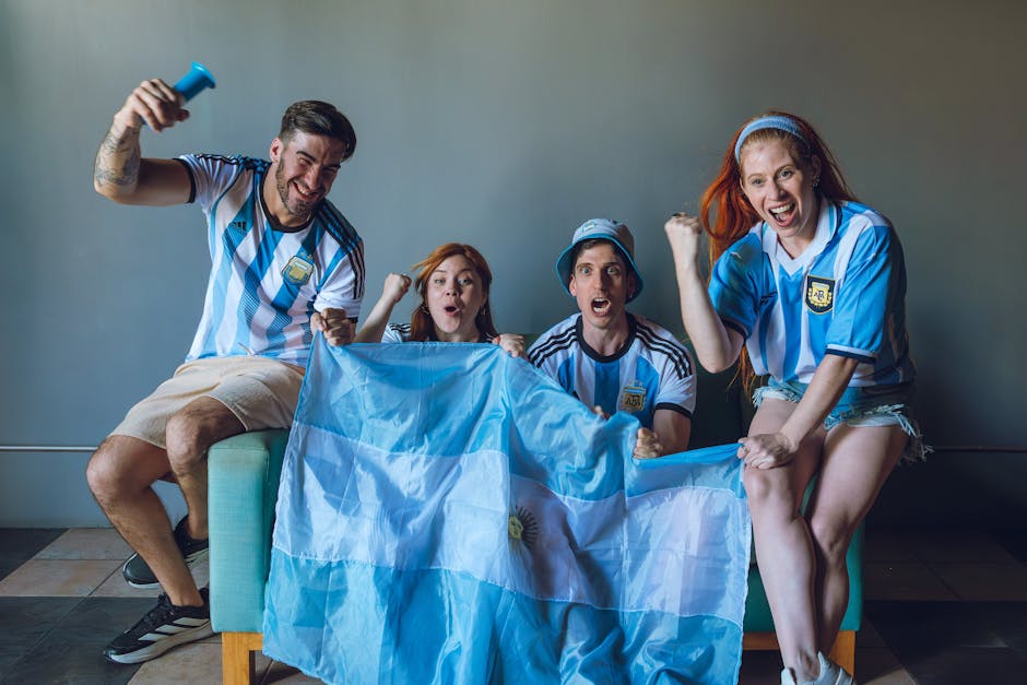 Group of excited Argentina soccer fans cheering with flag indoors.