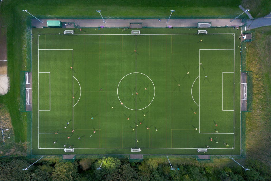 Top-down shot of a soccer match on a green field in Brighton, UK.