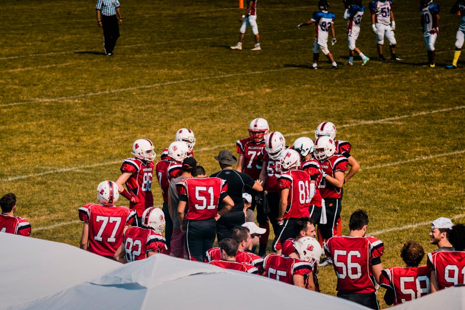 American football team huddling on field for strategy meeting during a game.