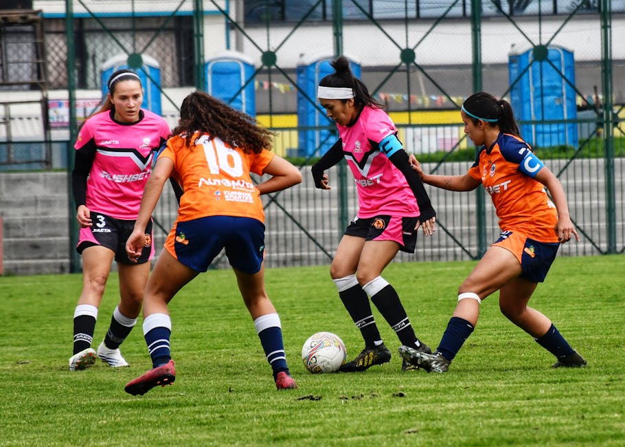 Female soccer players in action on a grassy field, showcasing teamwork and athleticism.