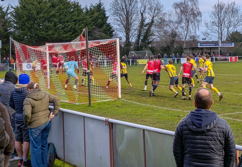 Action-packed amateur football match in progress, England. Enthusiastic crowd cheering.