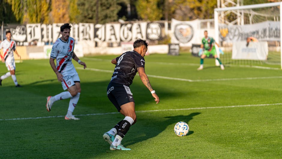 Players in action during an outdoor soccer game on a sunny day, highlighting sportsmanship.