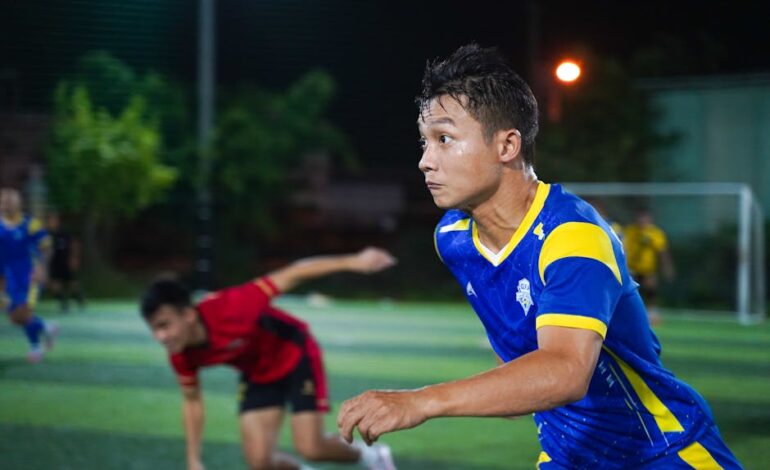 Intense soccer match under night lights, showcasing athletes' focus and energy.