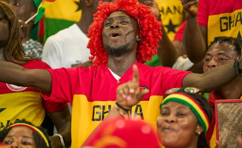 Fans passionately supporting Ghana at an intense soccer match in the stadium.