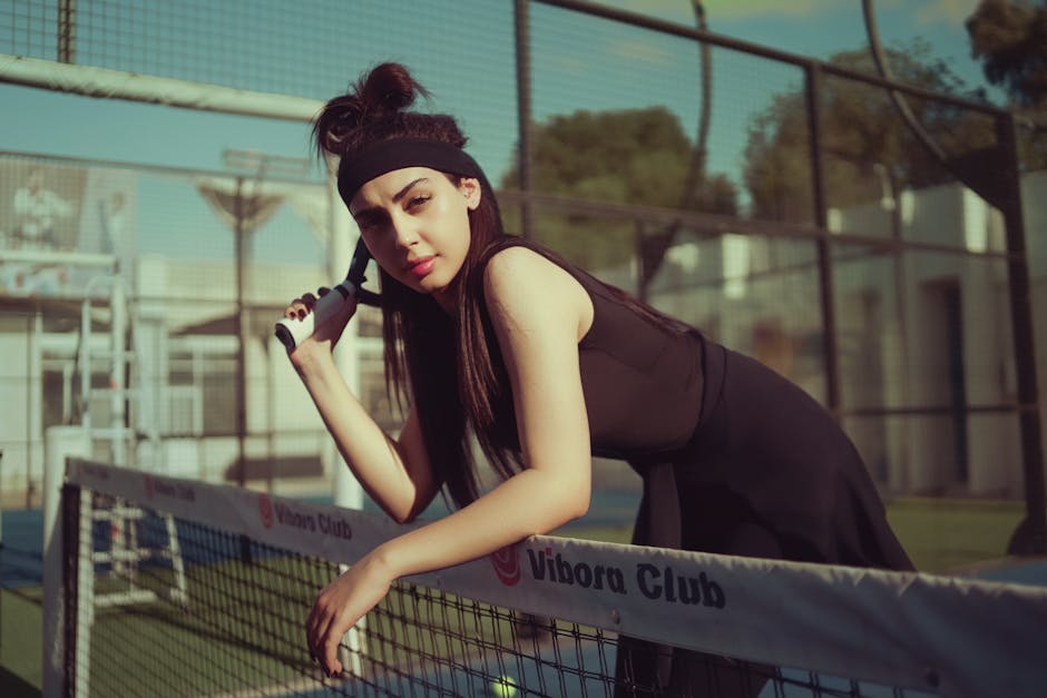 Confident young woman holding a tennis racket on a sunny day in Baghdad. Perfect for sports and lifestyle themes.