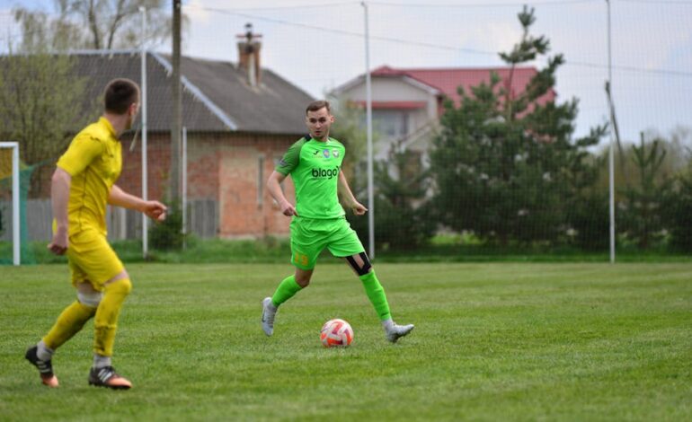 Two soccer players in action during an outdoor game on a grassy field.