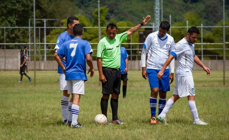 Soccer players and referee on a green field in Venezuela, mid-game action.