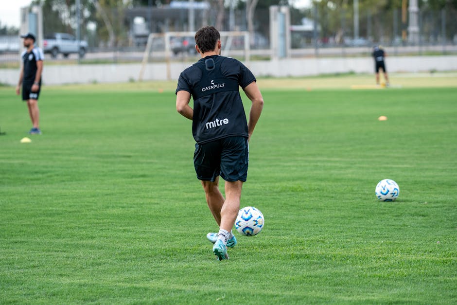 A soccer player trains on a lush green field, demonstrating skills and fitness dedication.
