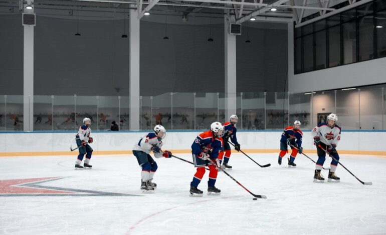 A group of athletes playing ice hockey indoors, showcasing teamwork and skills.