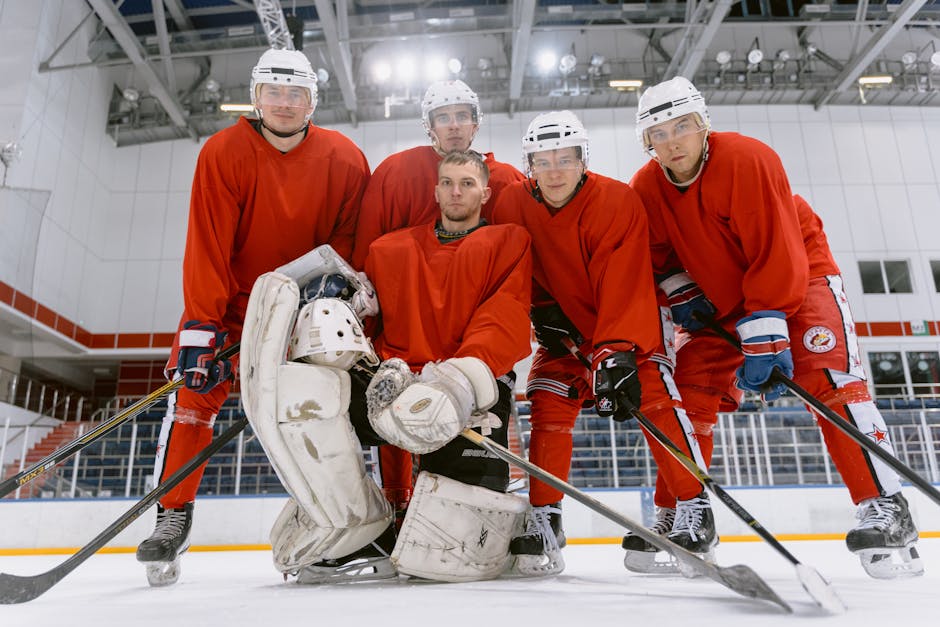 Group of ice hockey players in red uniforms posing on an indoor rink