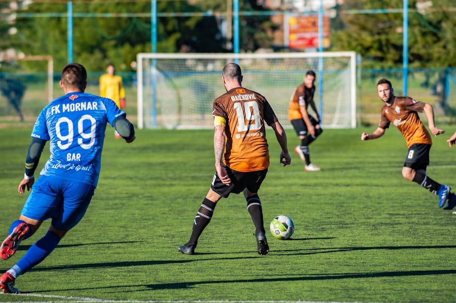 Action-packed soccer match featuring players in team uniforms on a sunny day.