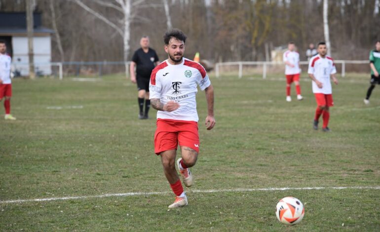 Soccer player running with focus during a competitive outdoor match.