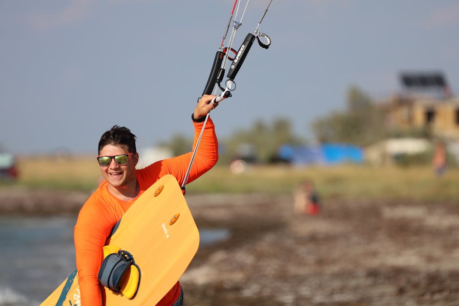 A happy man in orange wetsuit enjoying wakeboarding on the water, showcasing excitement in outdoor sports.