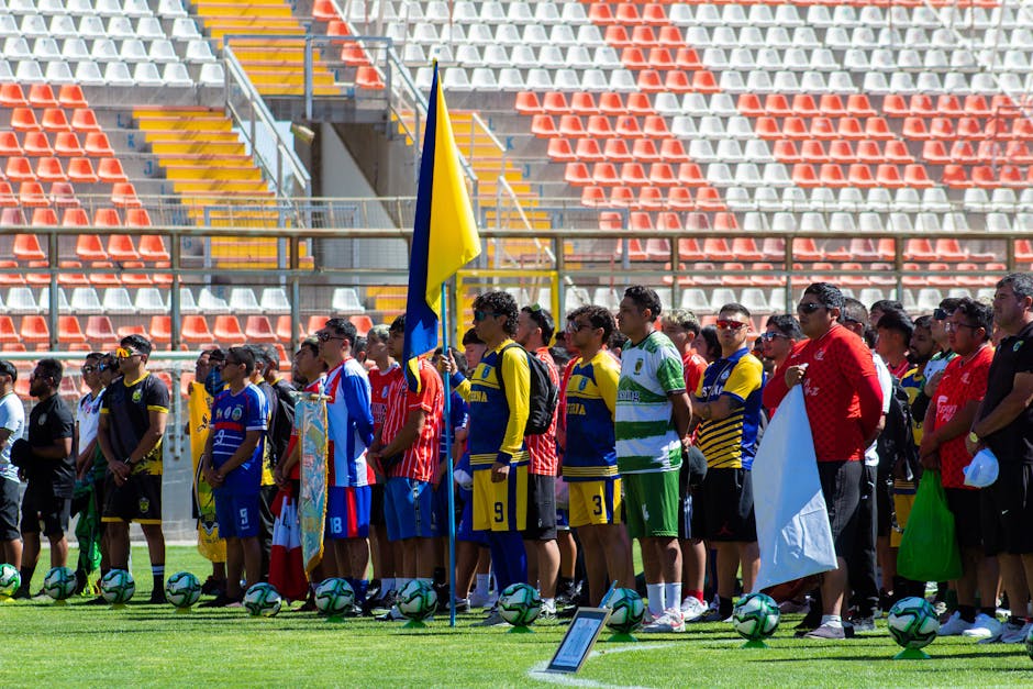 Colorful gathering of diverse soccer teams at a sunlit stadium.