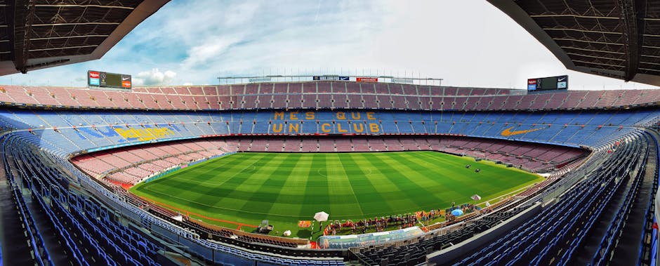 A wide-angle view of the iconic Camp Nou stadium, home to FC Barcelona, with empty bleachers.