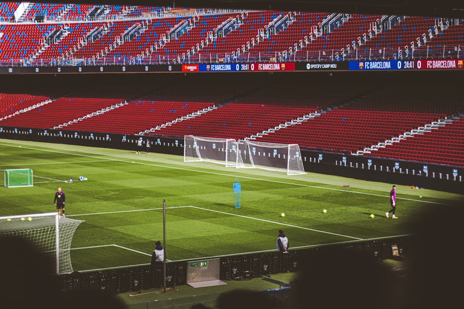 View of empty soccer field at FC Barcelona's Camp Nou with training equipment.
