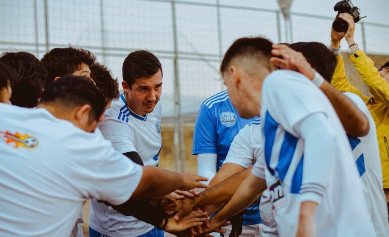 A soccer team gathers in a huddle for motivation before a match, fostering teamwork and unity.