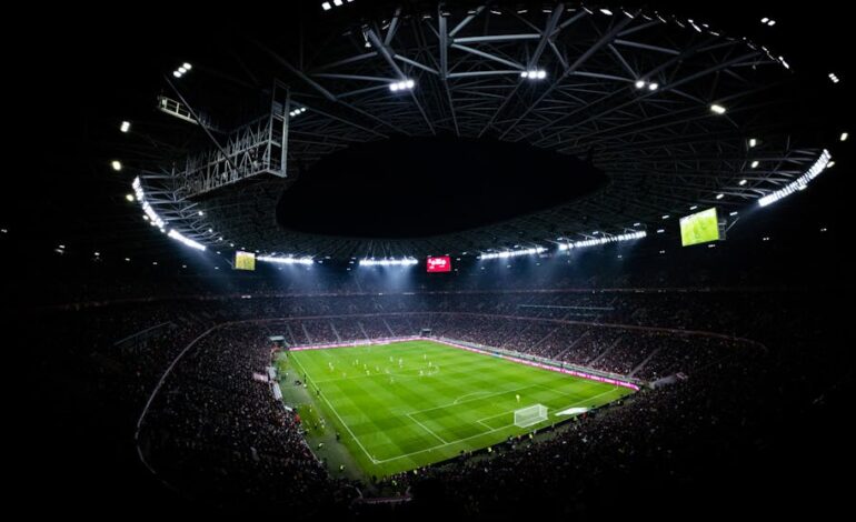 Aerial view of a night football match in Budapest. Illuminated stadium full of fans adds dramatic atmosphere.