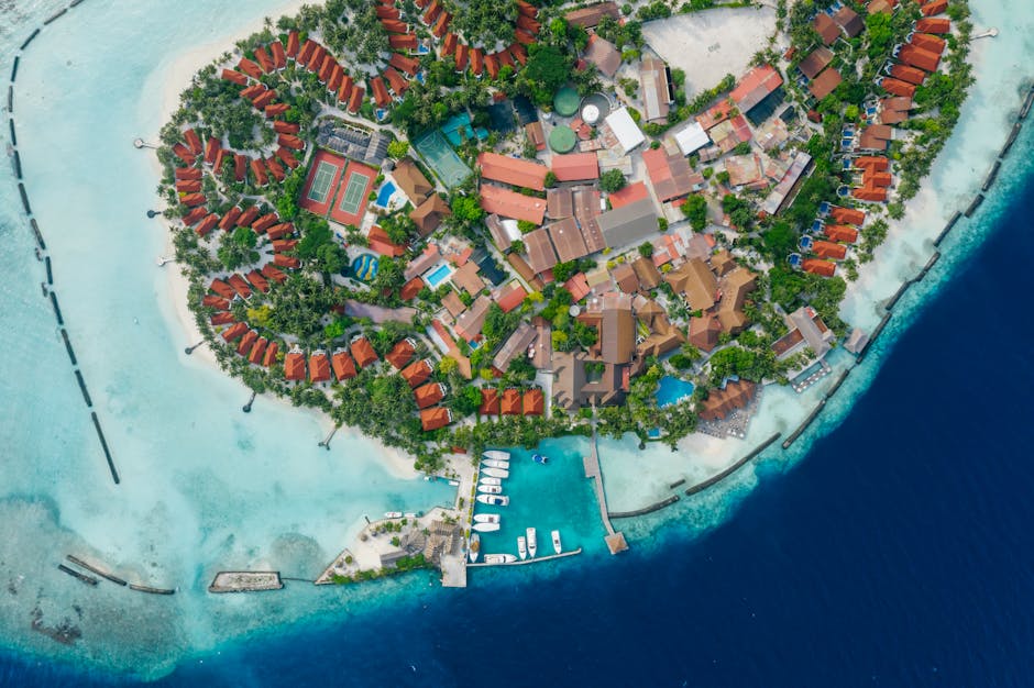Aerial photo of a luxurious island resort surrounded by turquoise waters.