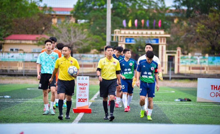 Football teams entering the field for Thạch Thất Open Cup 2025 in Hà Nội, Vietnam.