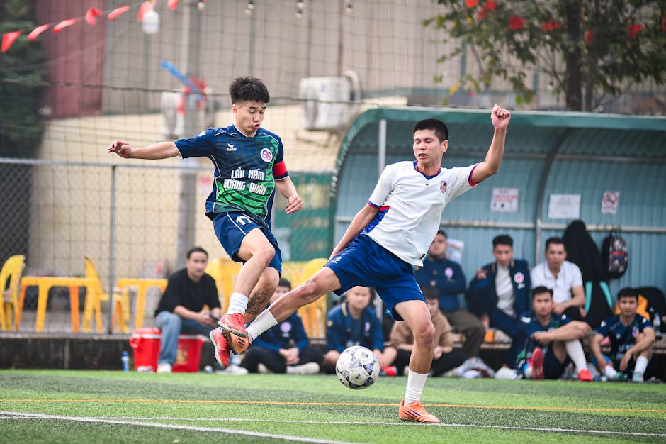 Dynamic action shot of a football match in Hanoi, Vietnam, showcasing skill and competition.