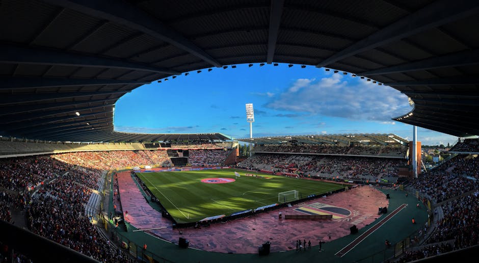 A lively crowd enjoys a football match at King Baudouin Stadium in Brussels.