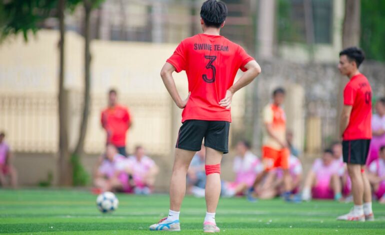 Amateur soccer players in vibrant jerseys on a field in Hanoi, Vietnam.
