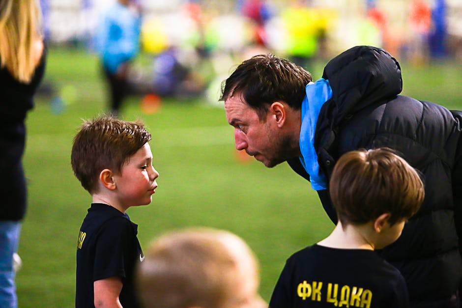 A soccer coach gives guidance to young boys during an indoor soccer training session.