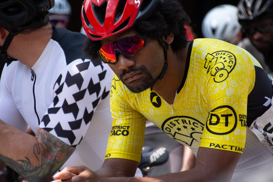 Focused cyclist in yellow apparel at a bike race preparing for competition.