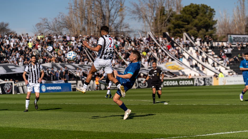 Dynamic scene of players in action during a soccer match at a crowded stadium.
