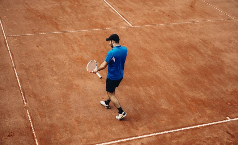 Athlete holding tennis racket on a clay court, summer sports action