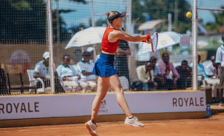 Tennis player in mid-air volley during a competitive outdoor match.