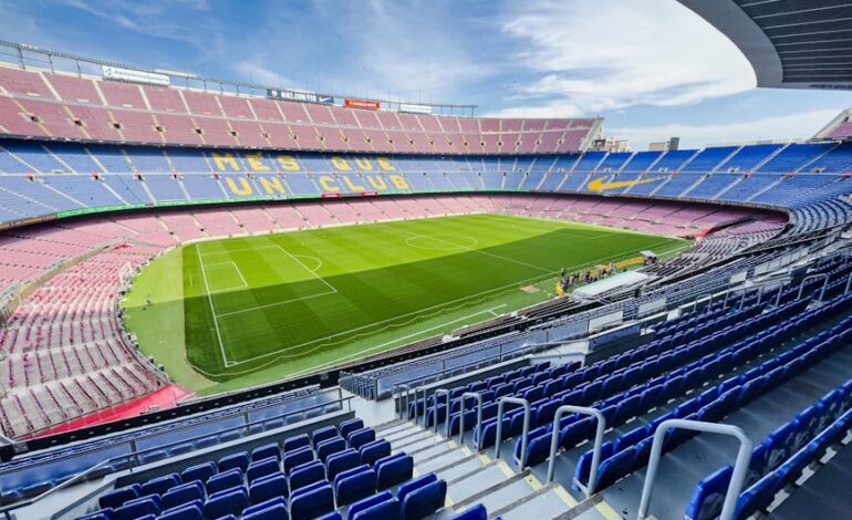 Wide-angle view of the iconic Camp Nou stadium in Barcelona, Spain, featuring its vibrant seating and green field.