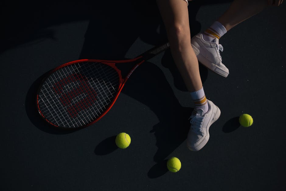 A close-up shot of a tennis player on a court with a racket and tennis balls.
