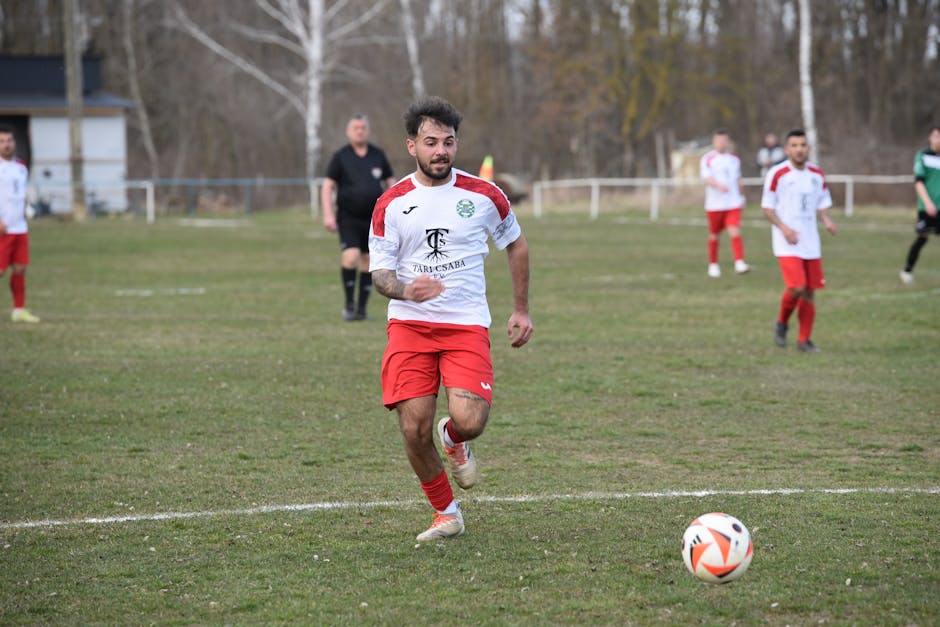 Soccer player running with focus during a competitive outdoor match.