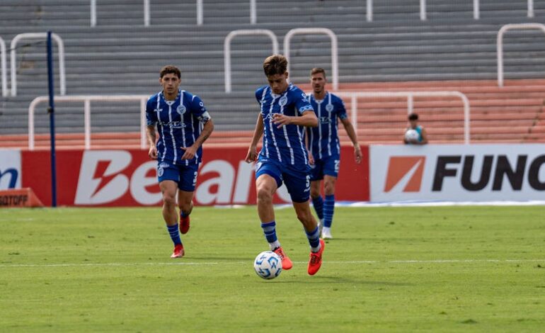 Action-packed soccer game with players in blue uniforms on the field.