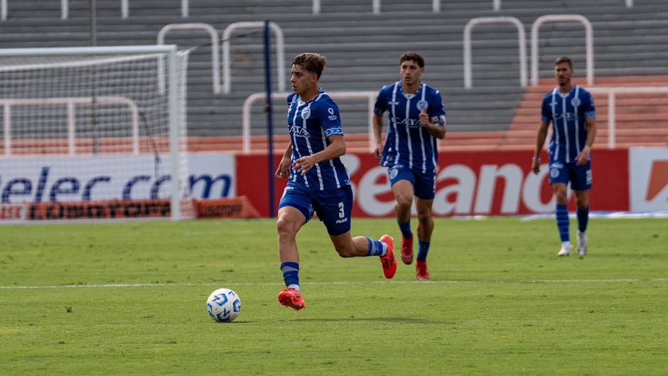 Exciting moment during a soccer match as players in blue uniforms take control of the ball on the field.