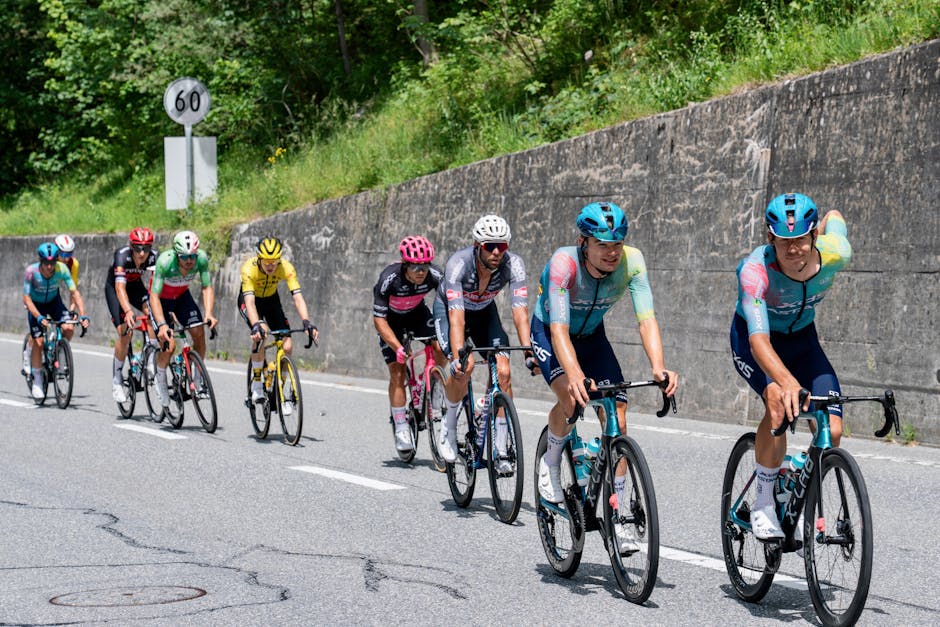 Cyclists competing in a race on a scenic mountain road in summer.