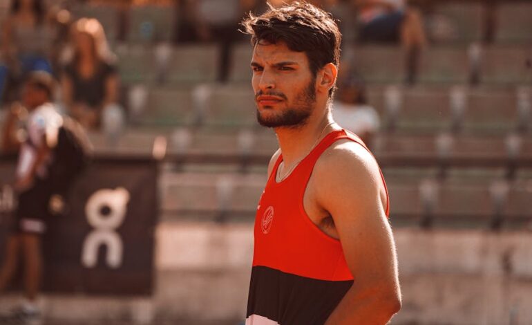 Portrait of a determined male athlete in a sports setting, capturing focused expression and athletic attire.