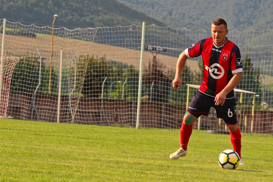 A soccer player in action on a sunny day at a field in Rajec, Slovakia.