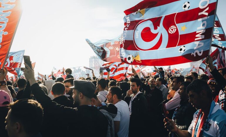 Energetic gathering with colorful flags at a lively outdoor event on a sunny day.