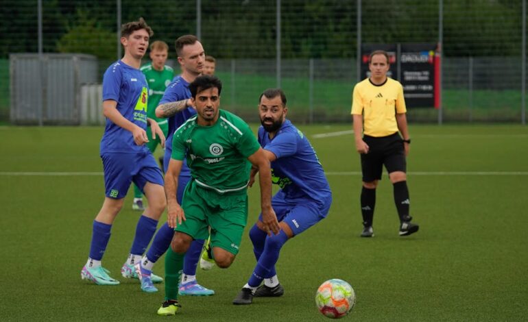 Intense soccer match between two teams, showcasing athletic performance on a grass field.
